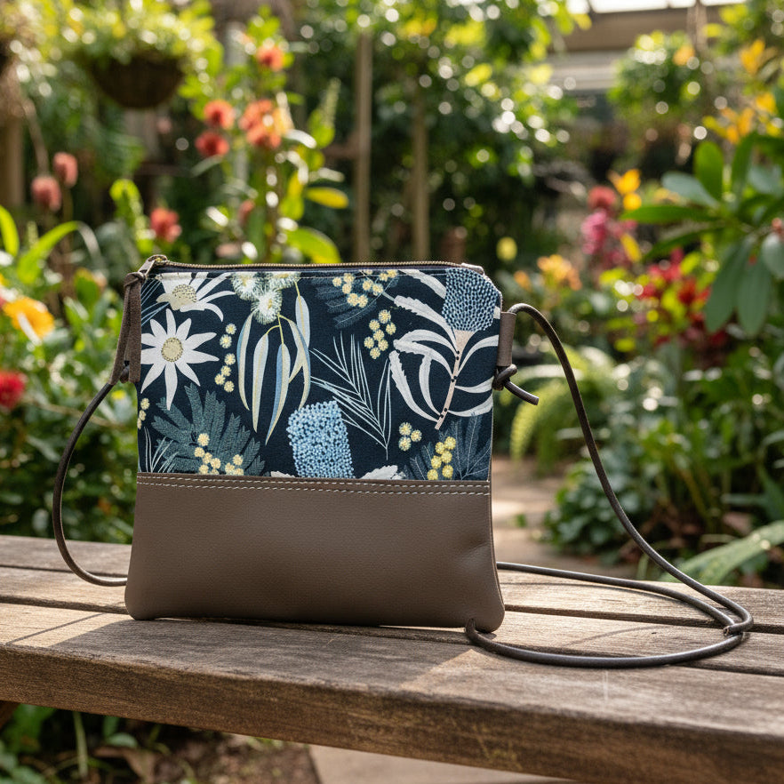 Floral-patterned handbag on a wooden bench with a garden background