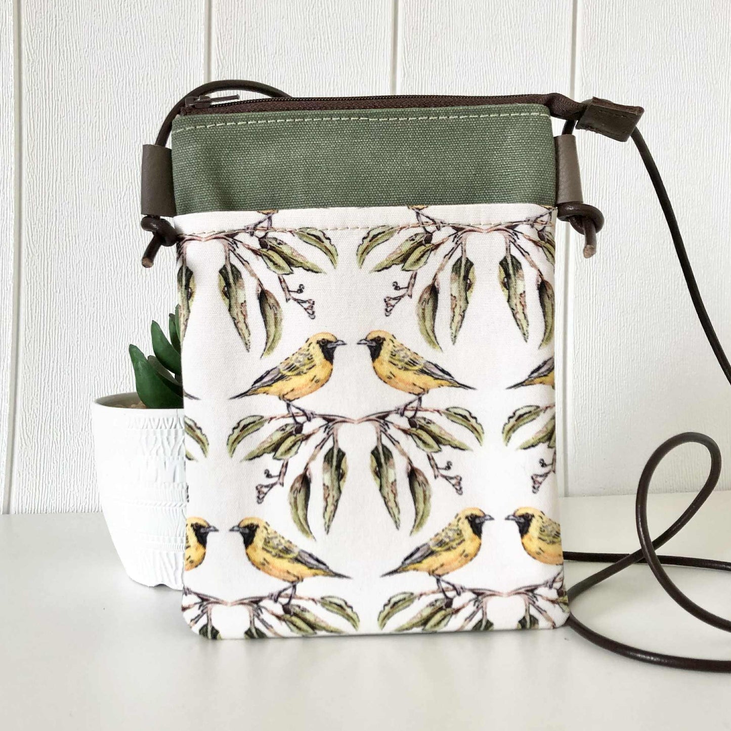 Handbag with bird and leaf pattern on a white surface