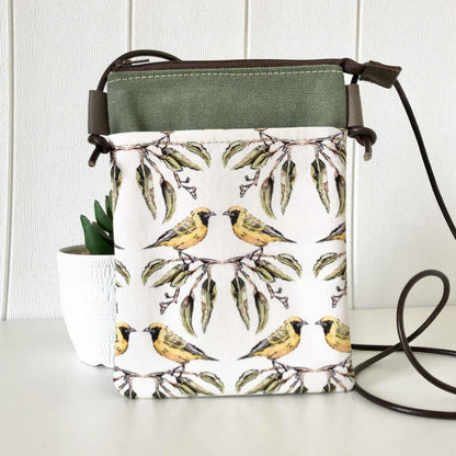 Handbag with bird and leaf pattern on a white surface