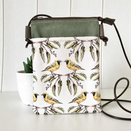 Handbag with bird and leaf pattern on a white surface