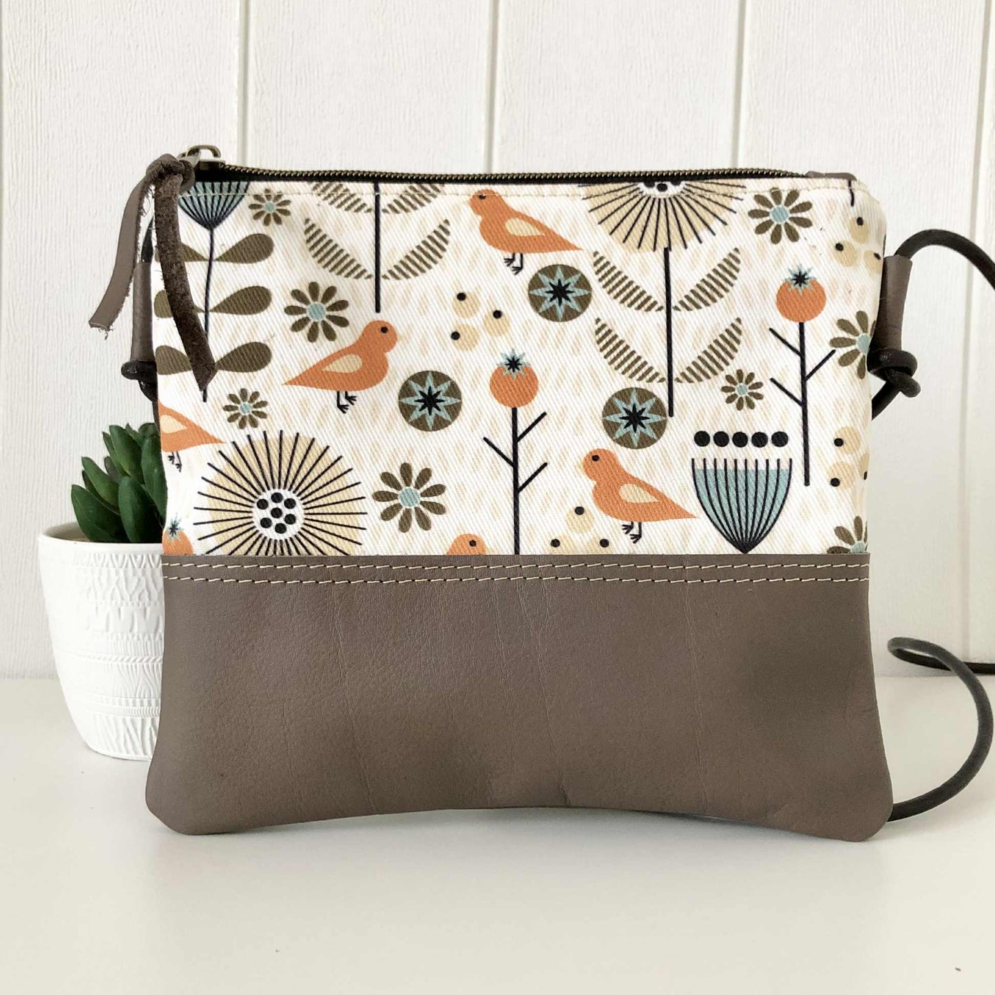 bird fabric and brown leather sling bag